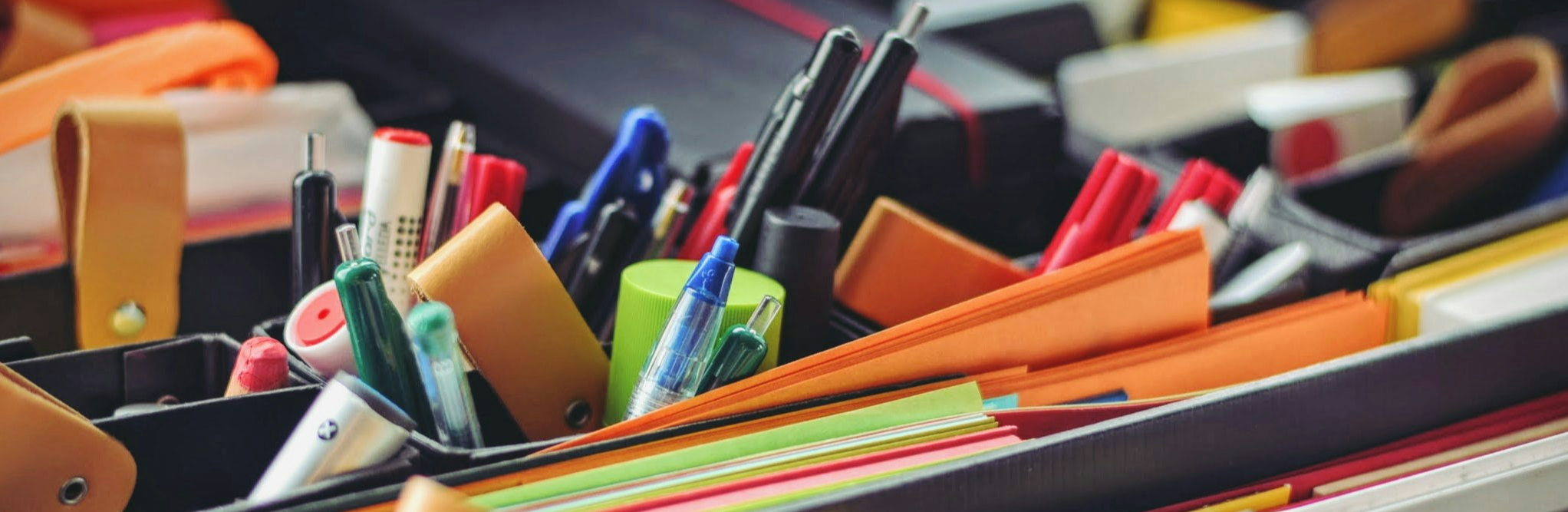 Coloured paper in folder with pens and stationary