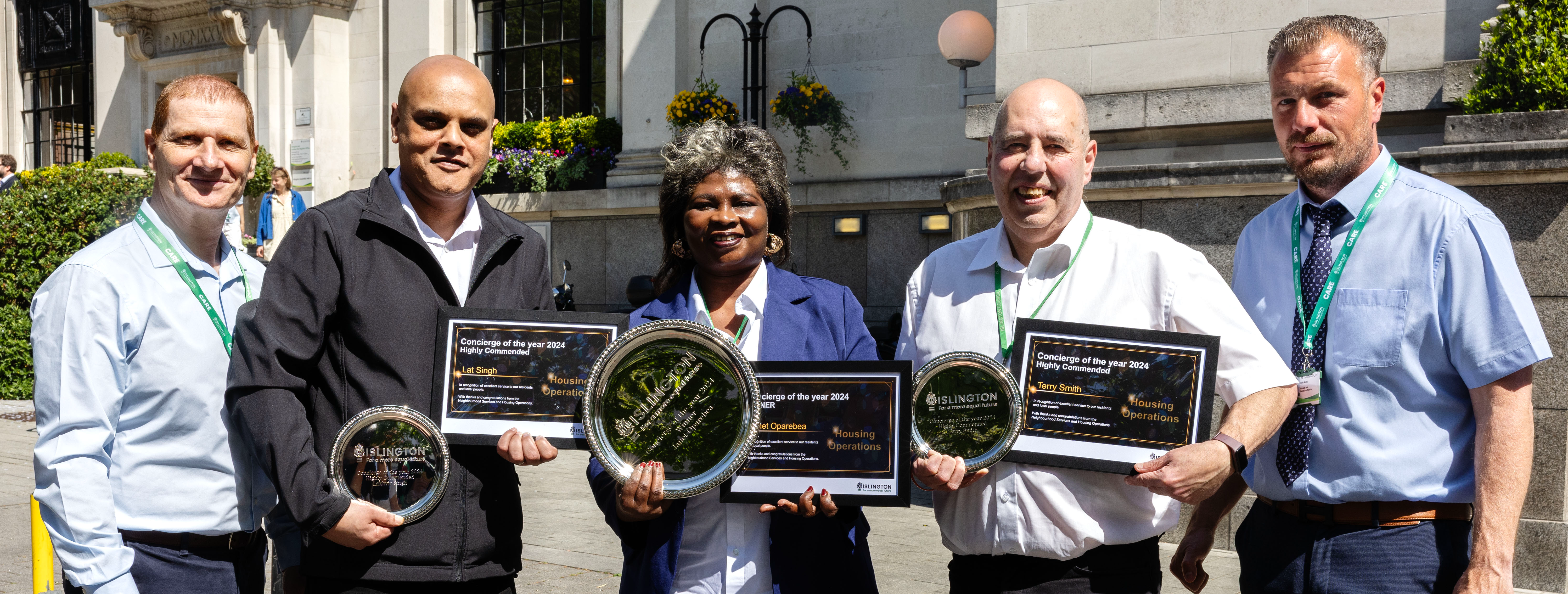 Group of people smiling at the viewer and holding awards