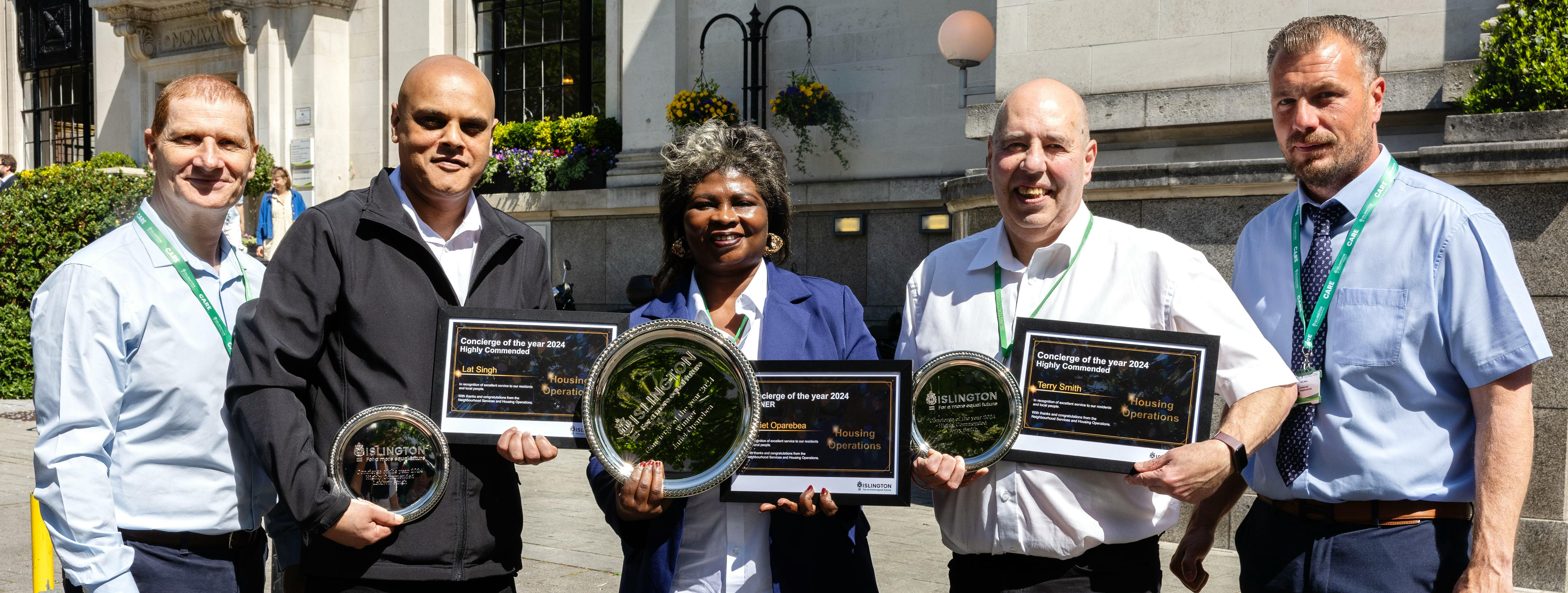 Group of people smiling at the viewer and holding awards