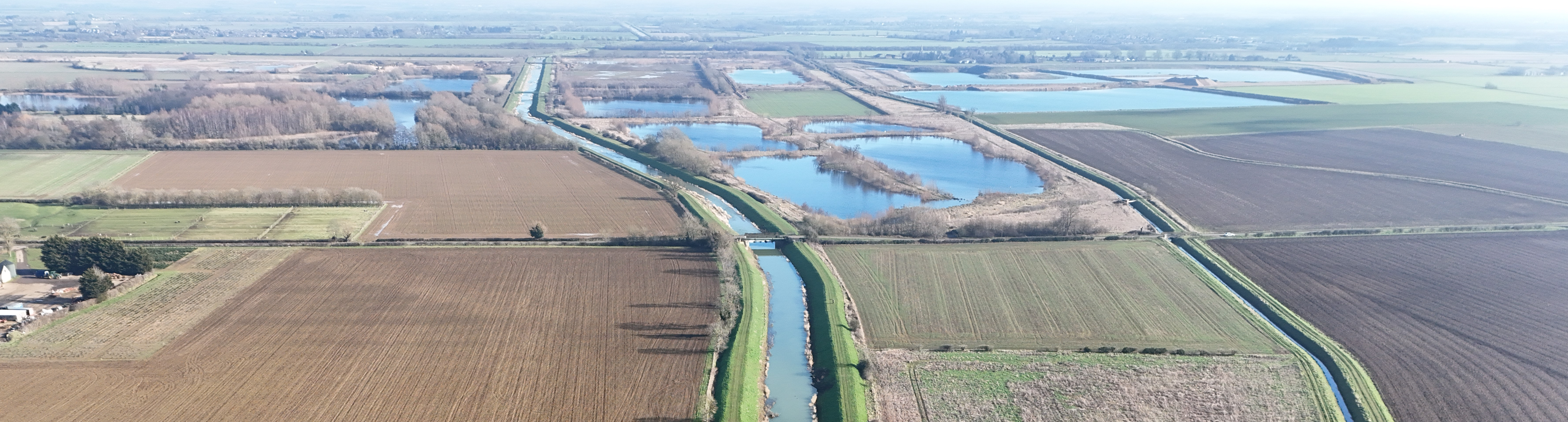 Drone photograph of the Maxey Cut. The Cut is central to the photo with farmland visible on either side.