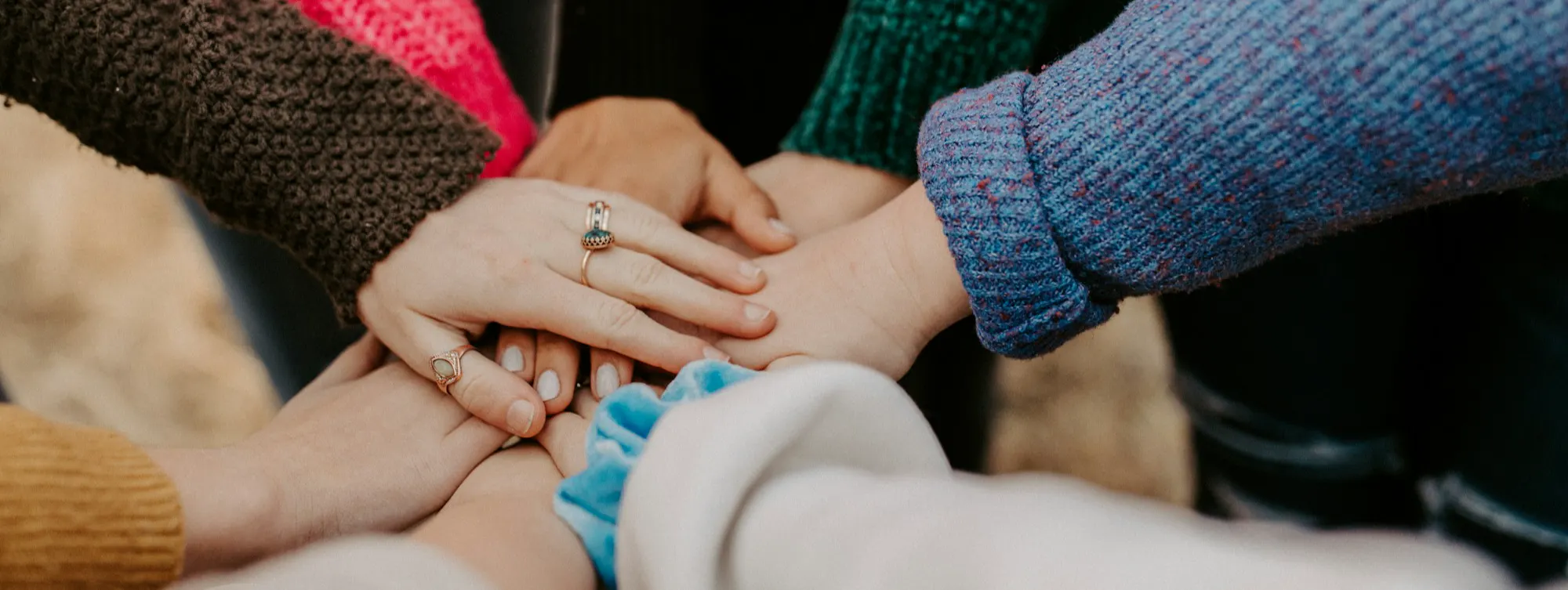 8 hands on top of each other in a circle .