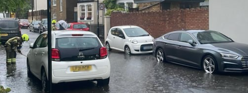 A picture of the a flooded street in Ealing and emergency responder