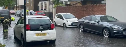 A picture of the a flooded street in Ealing and emergency responder