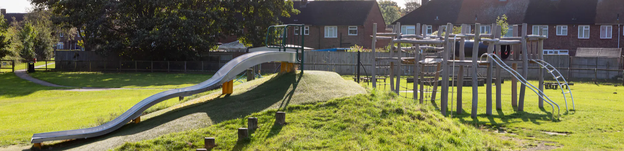 Outdoor play area with wooden climbing frame and a slide