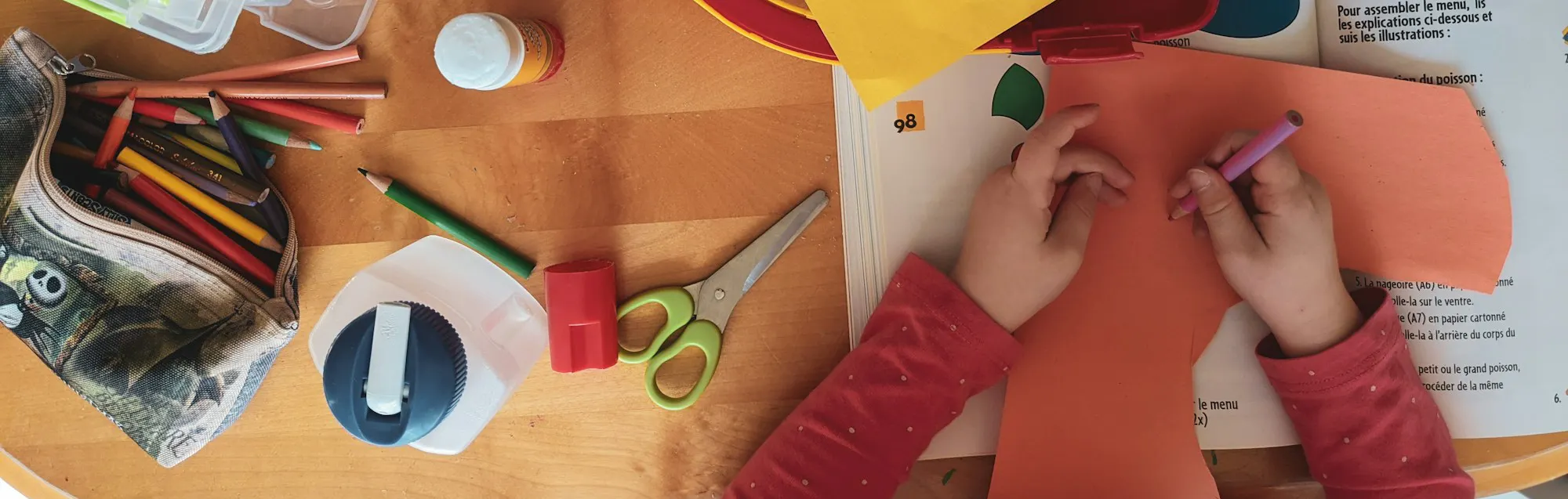 Child drawing on coloured paper