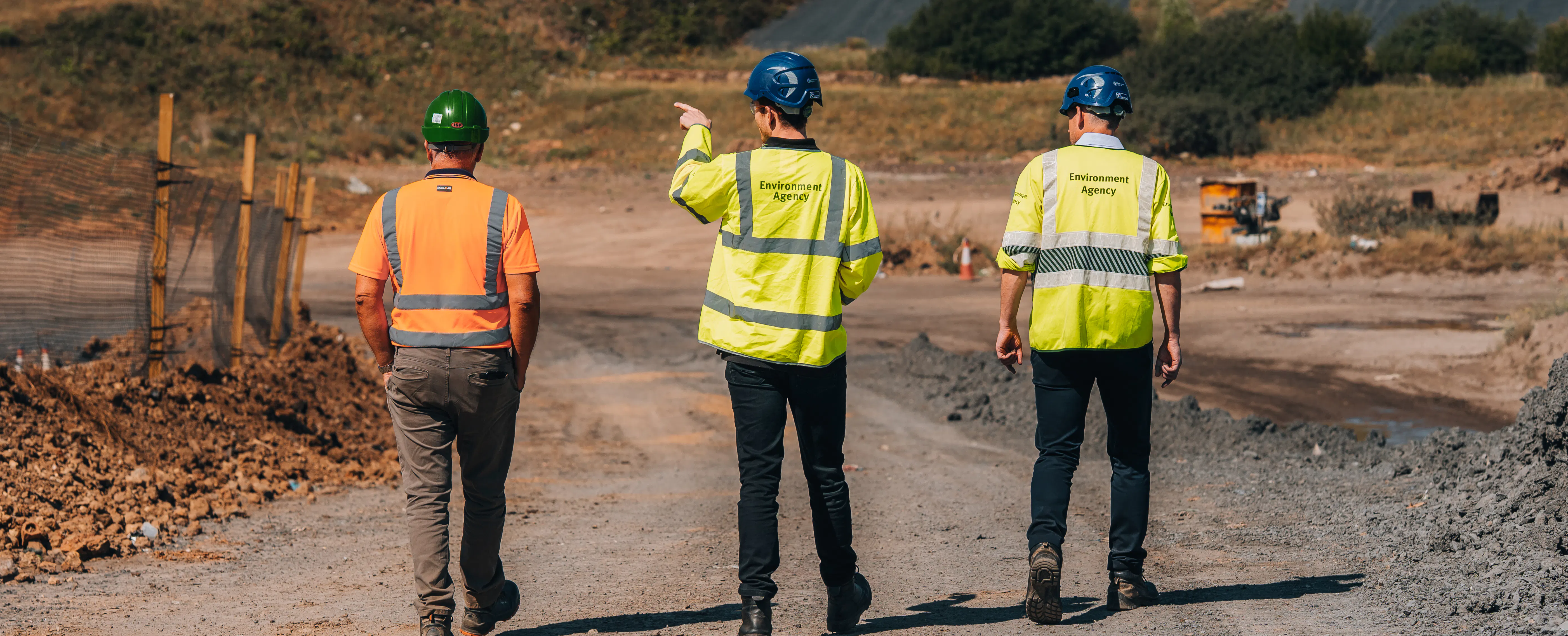 Environment Agency staff and a site worker inspecting a landfill site.