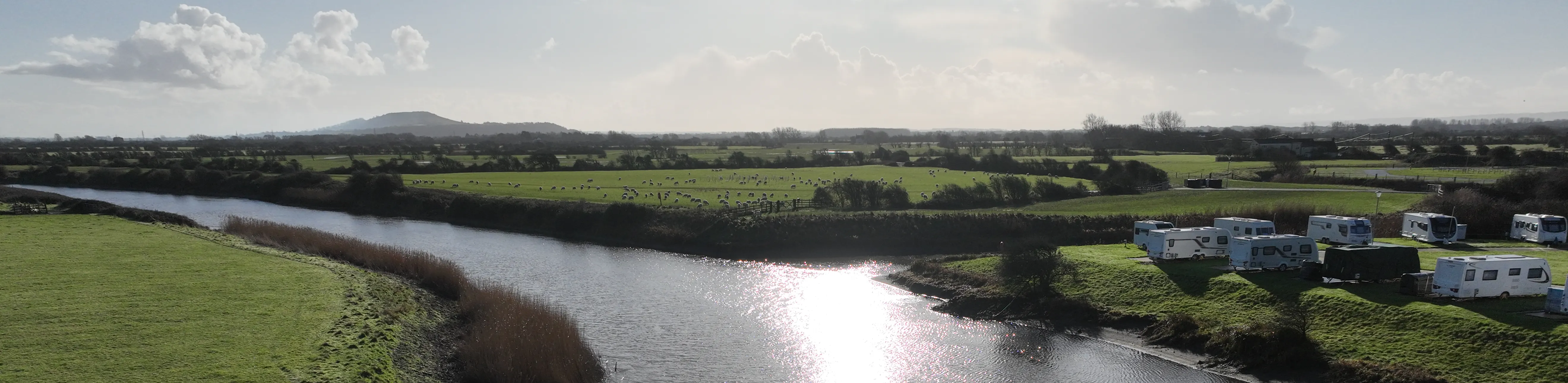 Environment Agency staff talking to cyclist with Glastonbury Tor in the background