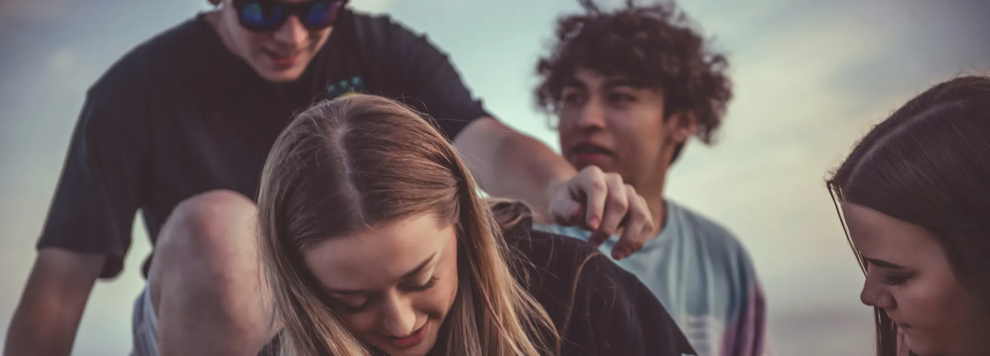 This photograph captures a group of young people gathered closely together outdoors