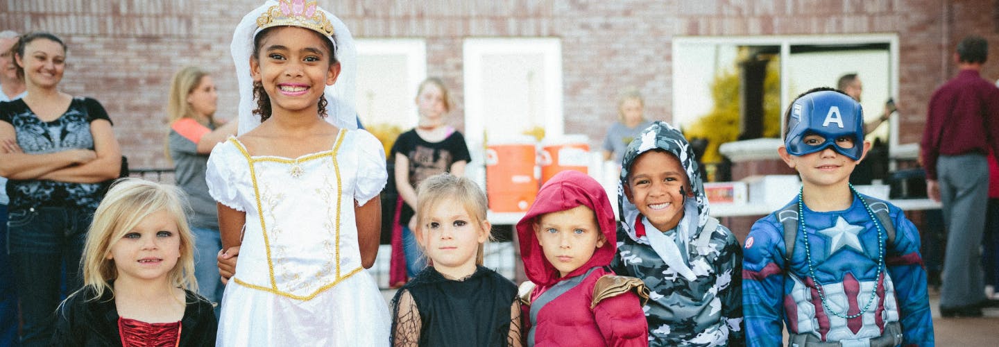 A group of smiling children wearing fancy dress costumes