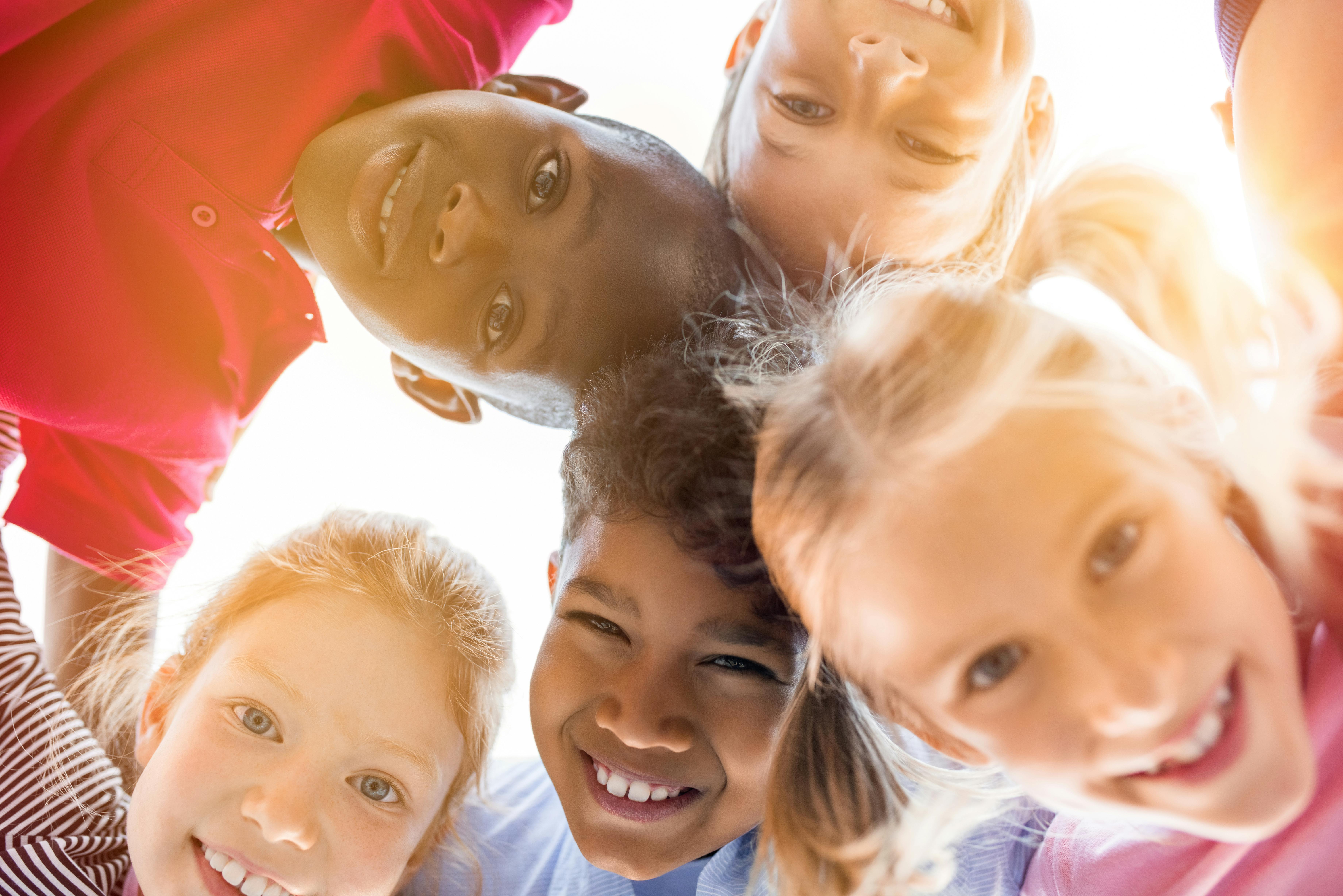 young children huddled together smiling at the camera