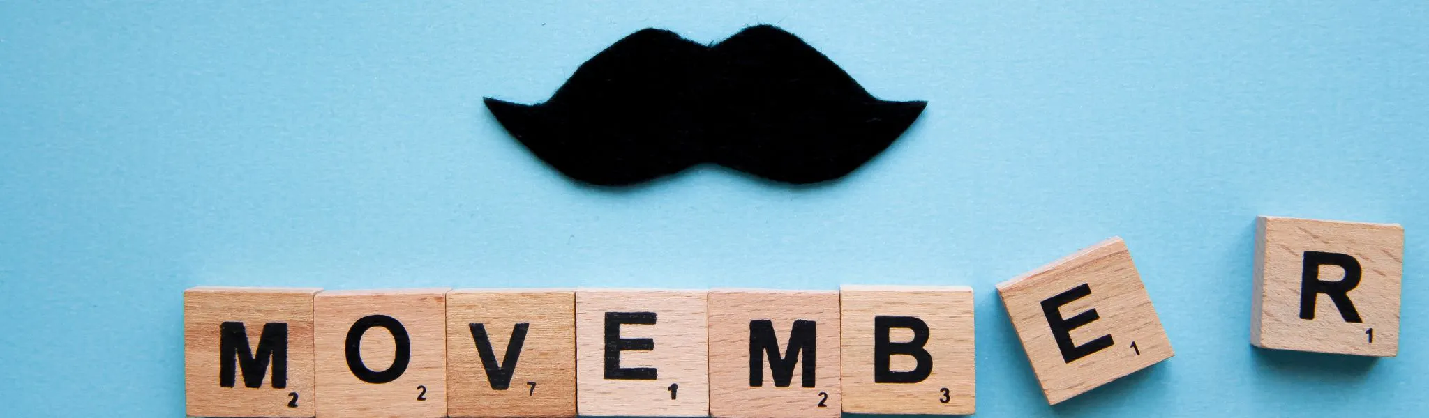 An image scrabble tyles spelling movember and a moustache