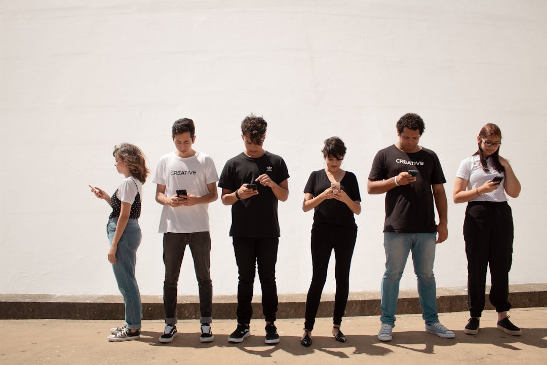 A group of young people looking down at their phones