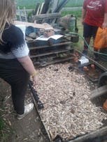 An image of a young girl on an allotment site, putting down mulch