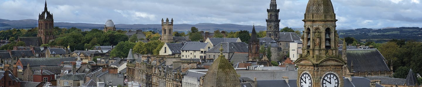 Image of the skyline over Paisley town centre showing the tops of buildings with mountains in the distance