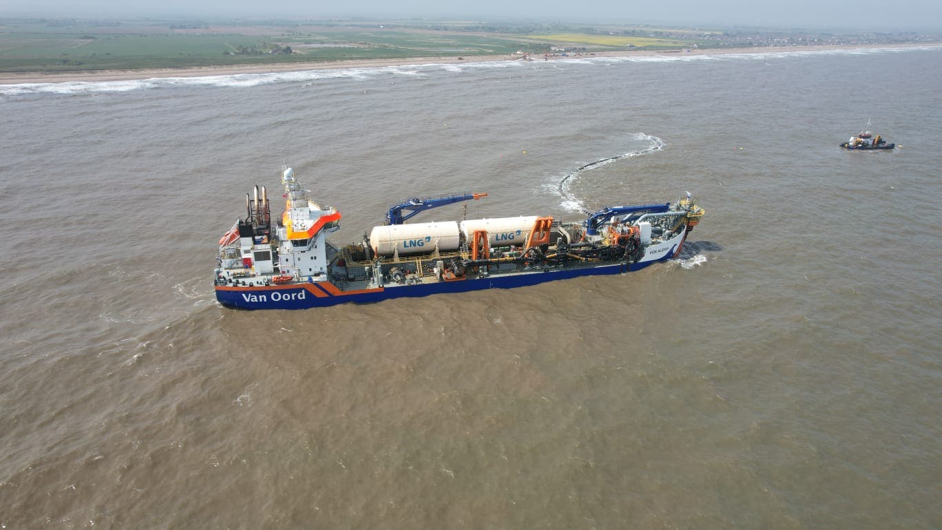 The Van Oord dredger 'Vox Alexia' moves to the next beach nourishment site with the land it better protects on the horizon