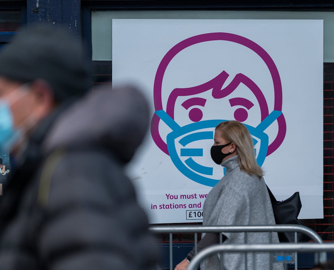 Scene in front of Barking Station showing a sign encouraging people to wear face masks