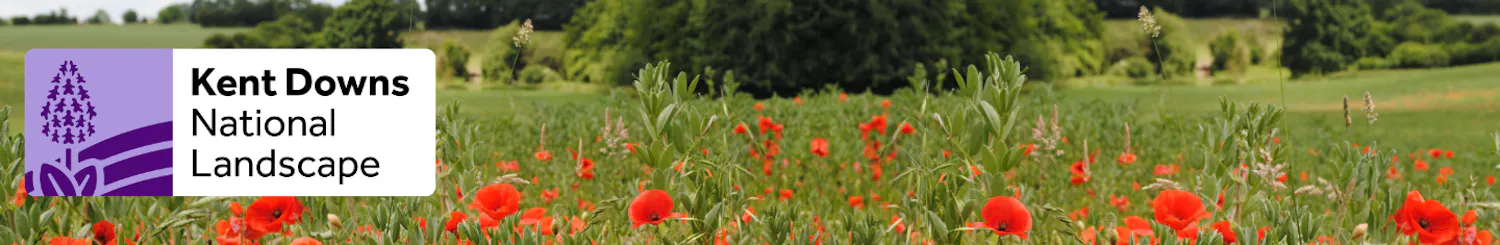 Kent Downs National Landscape logo and a photo of a field with poppies in the foreground and trees in the background