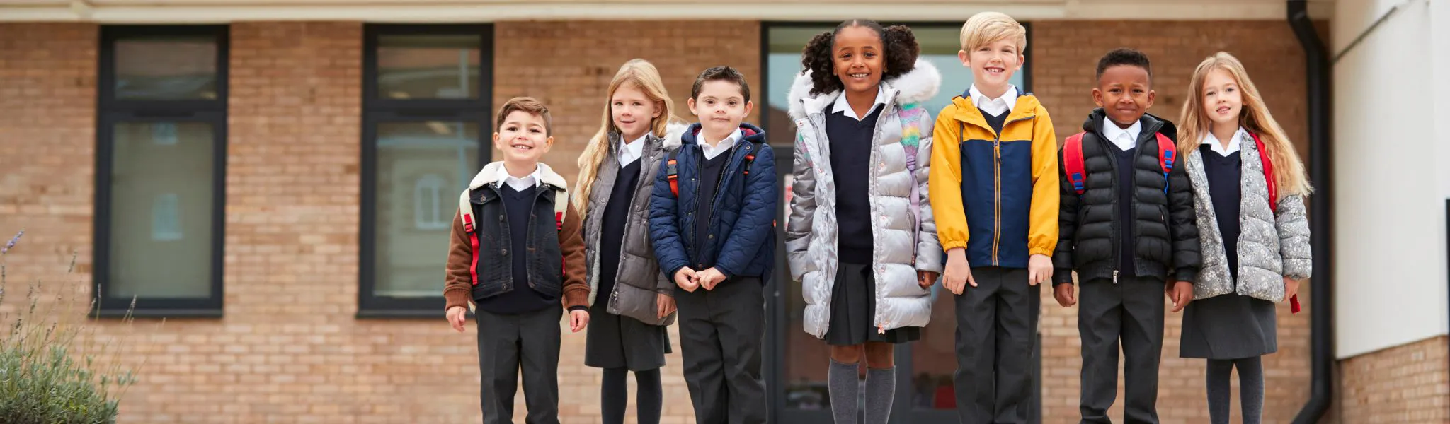 Group of students standing in front of their school.