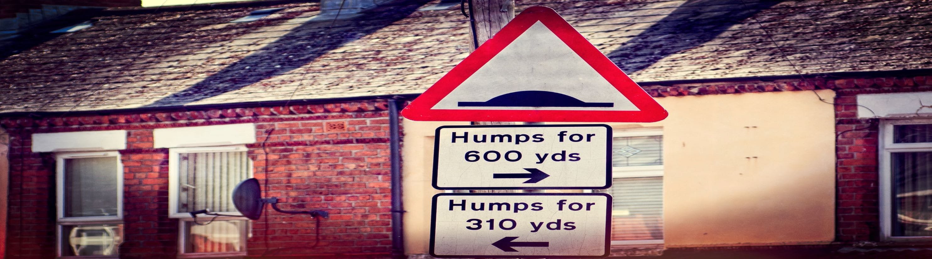 Photo of road signs warning of traffic humps.