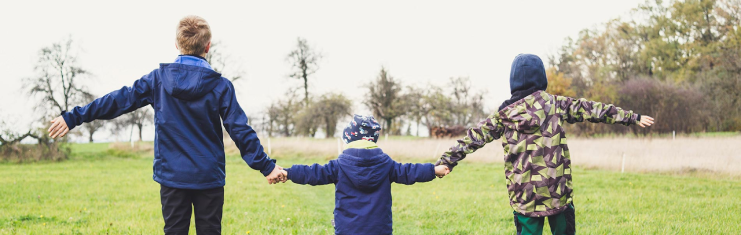 The image of three children holding hands