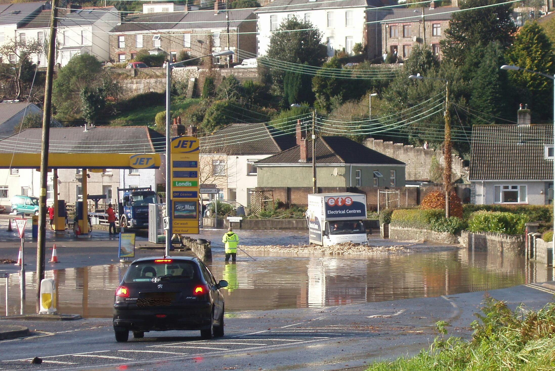 Deep flood water covering the A390 in front of the Jet garage.
