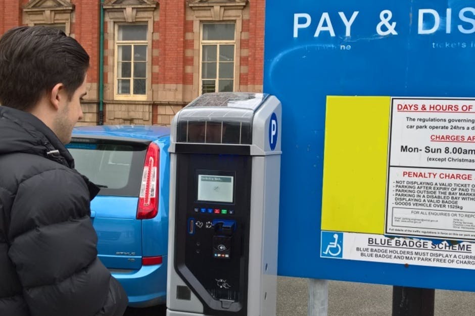 Man at car parking meter photograph
