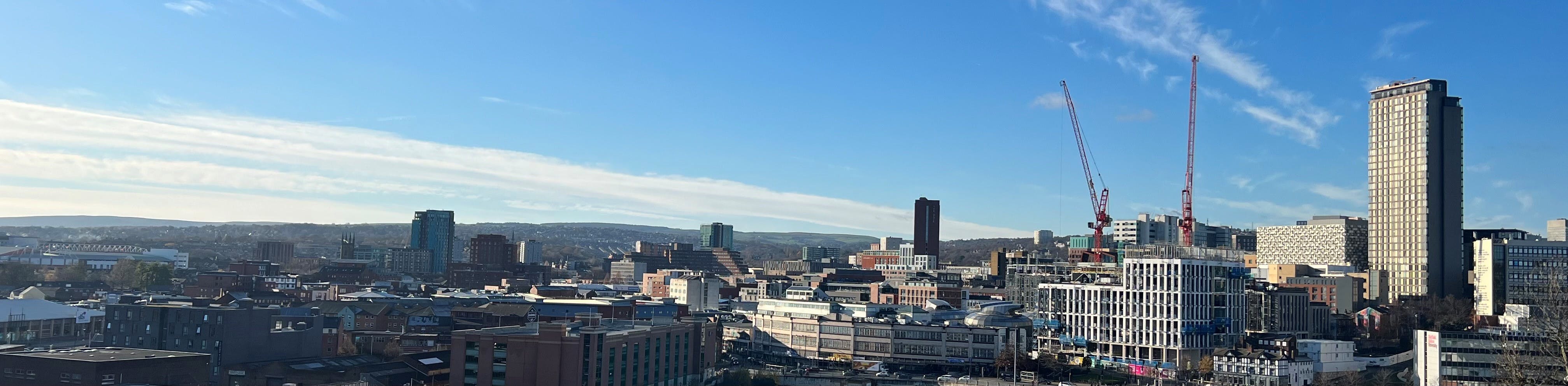 Sheffield skyline in Autumn sun showing buildings and development in the city centre and hills beyond