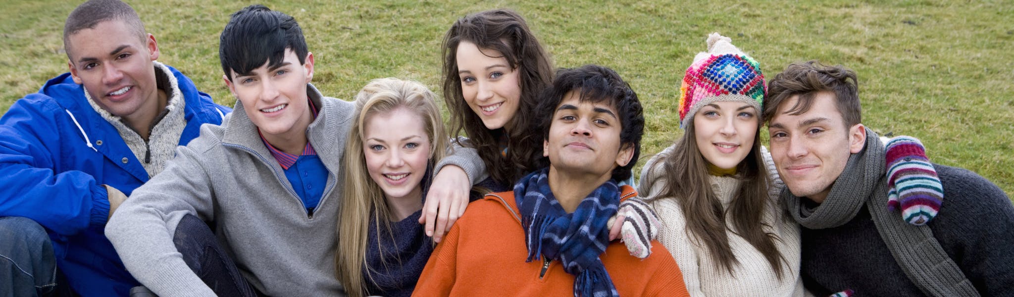 A group of people sitting together smiling.