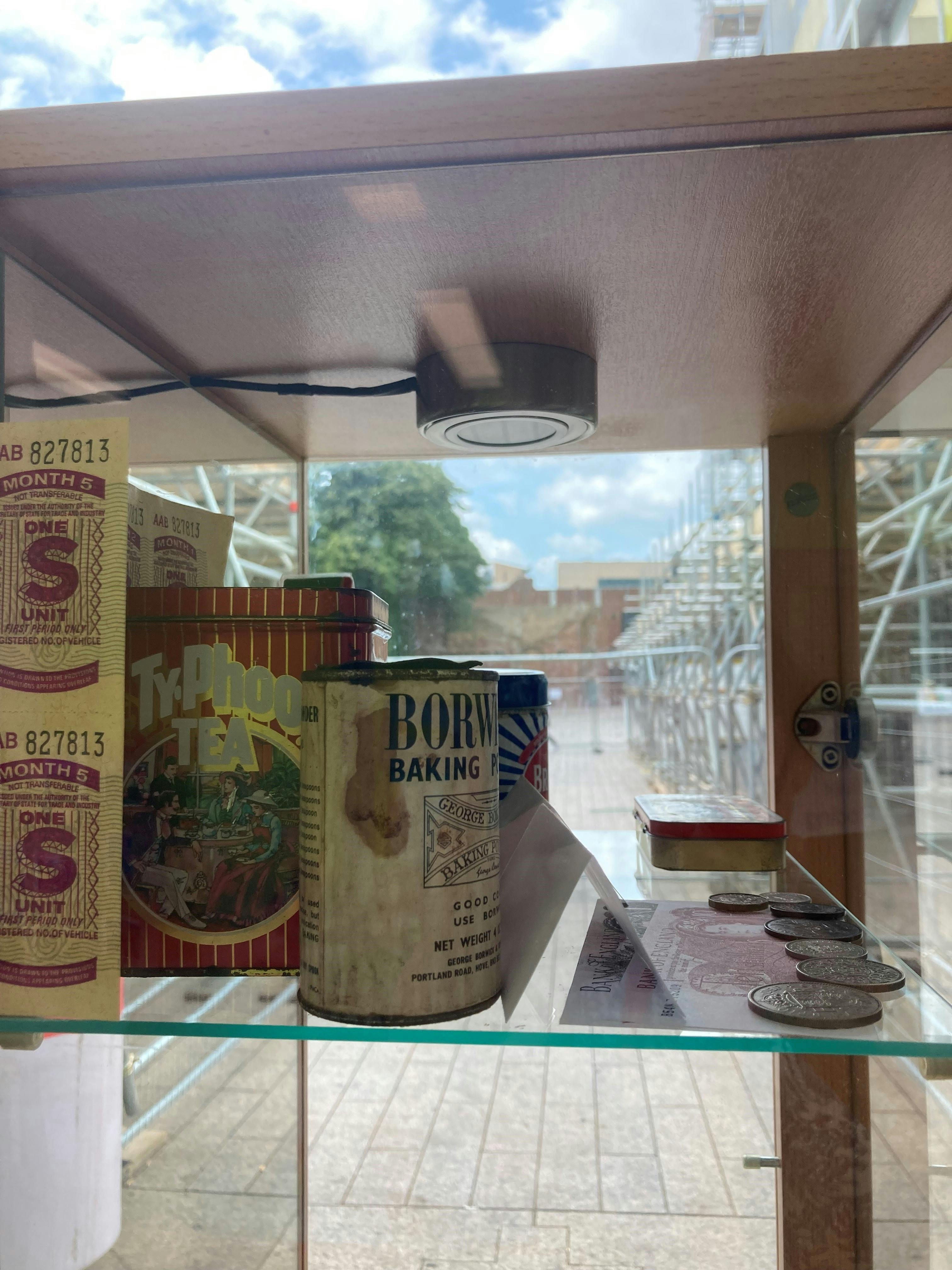 George's cabinet at BLC, tins and coins showing shopping in past times