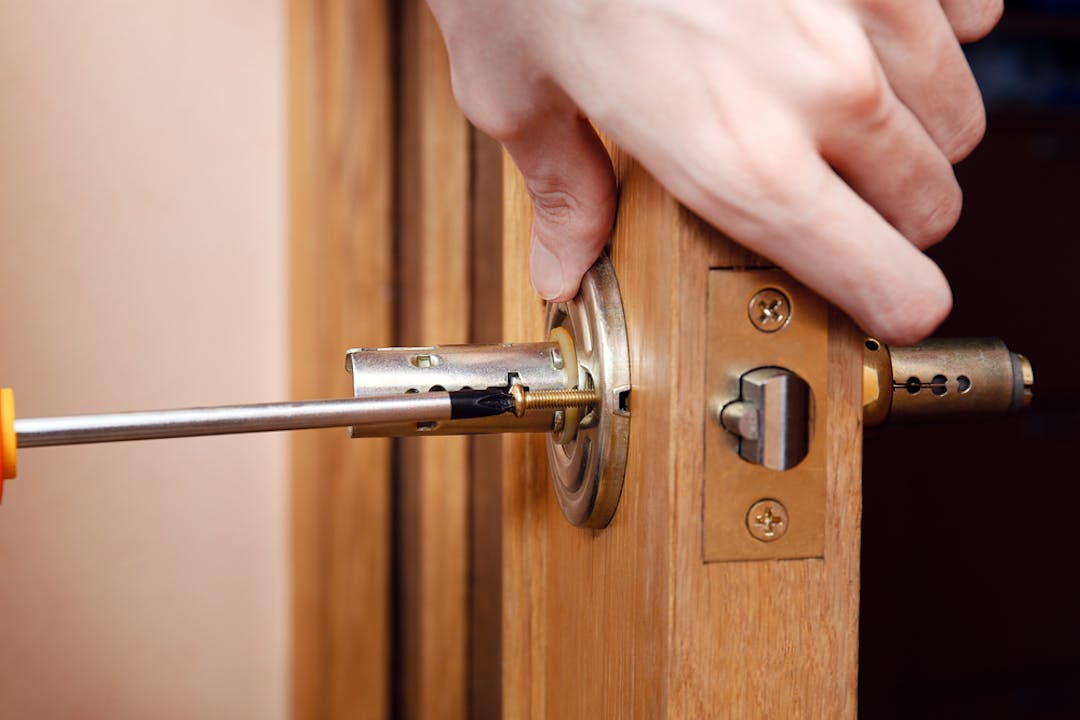 Photo of someone repairing a door handle