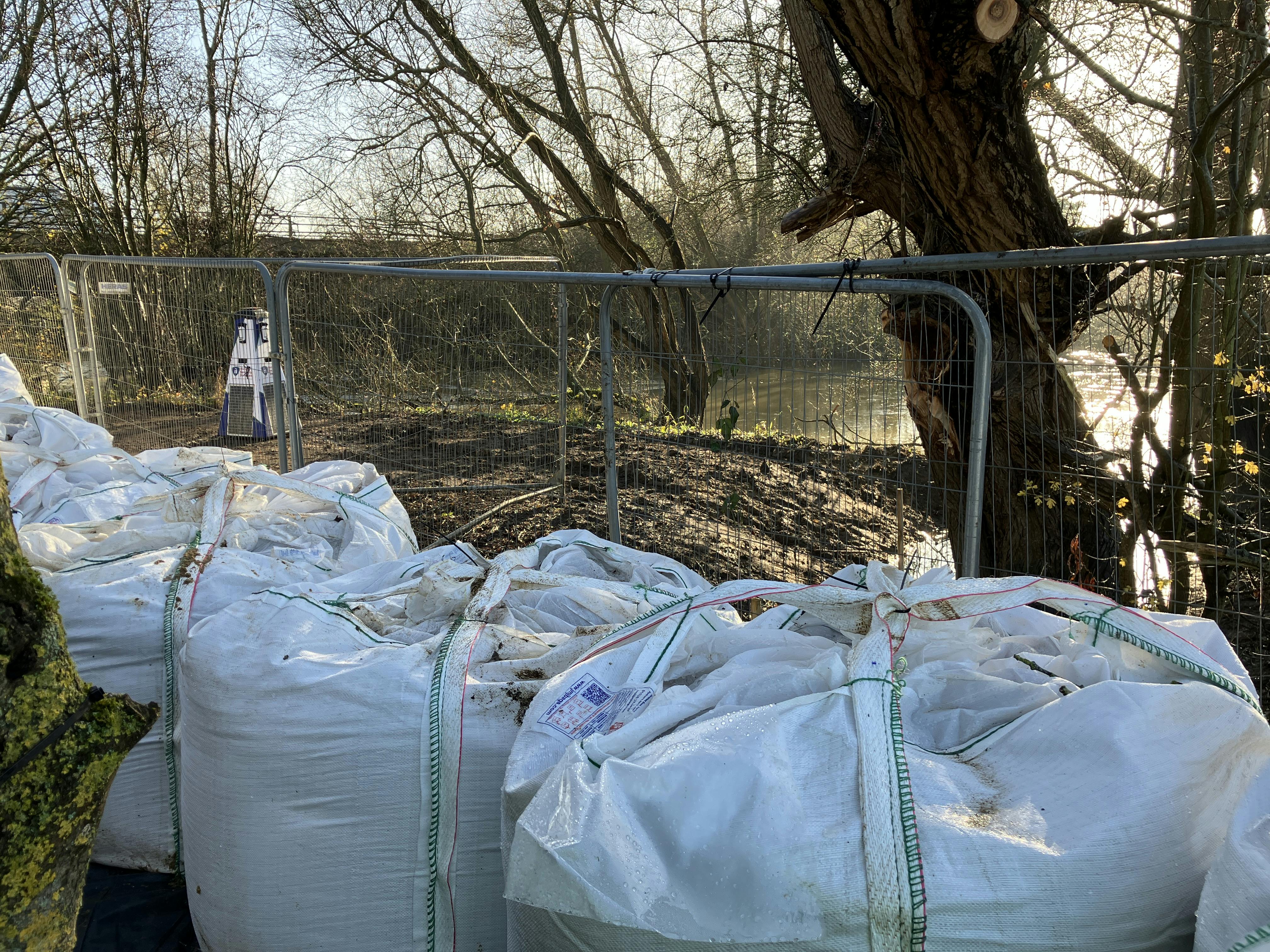 Kidlington - Heras fencing sandbags and motion detection security device next to the river.JPG