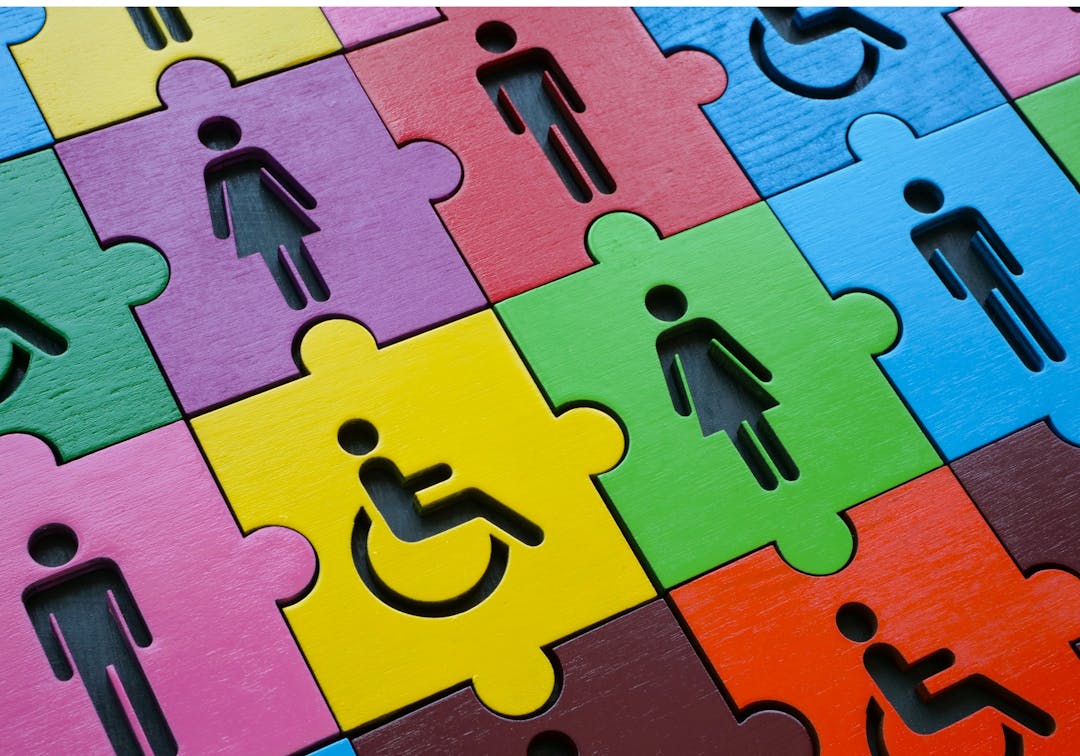 a man a woman and a person in wheelchair shapes cut out in a coloured background
