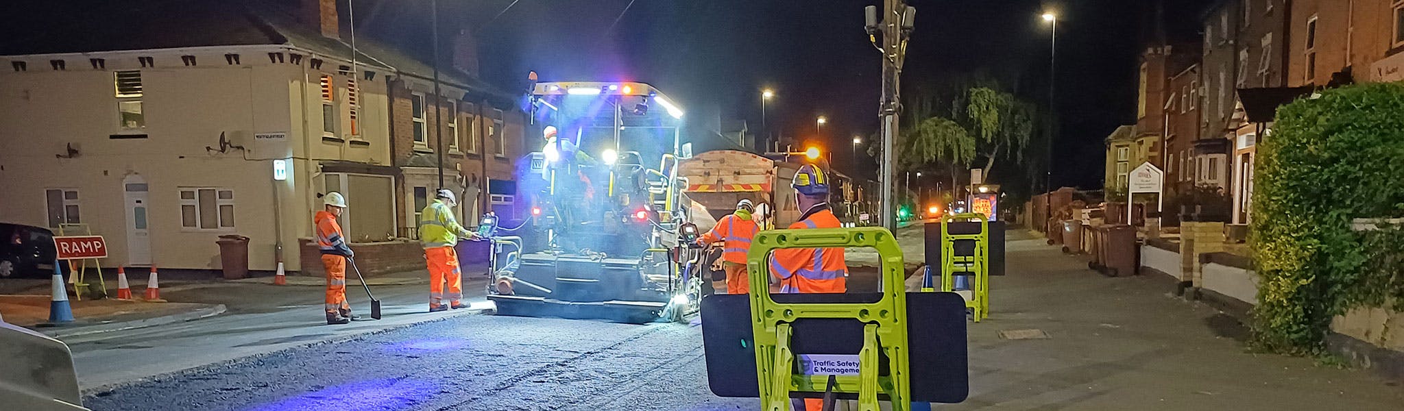 An image of  people undertaking roadworks at night