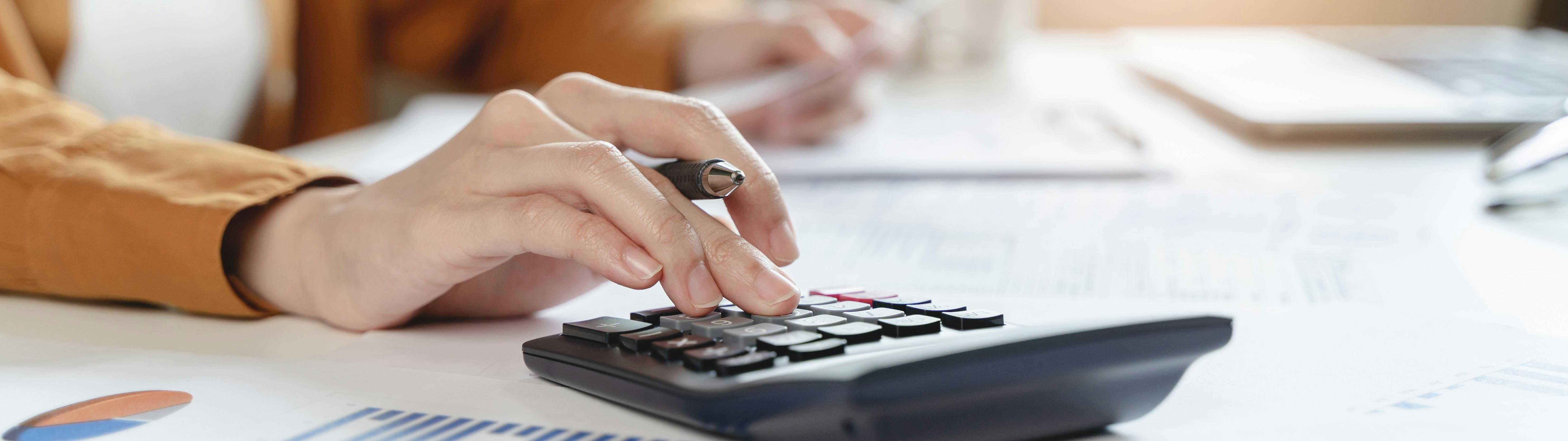 Close up of a hand using a calculator