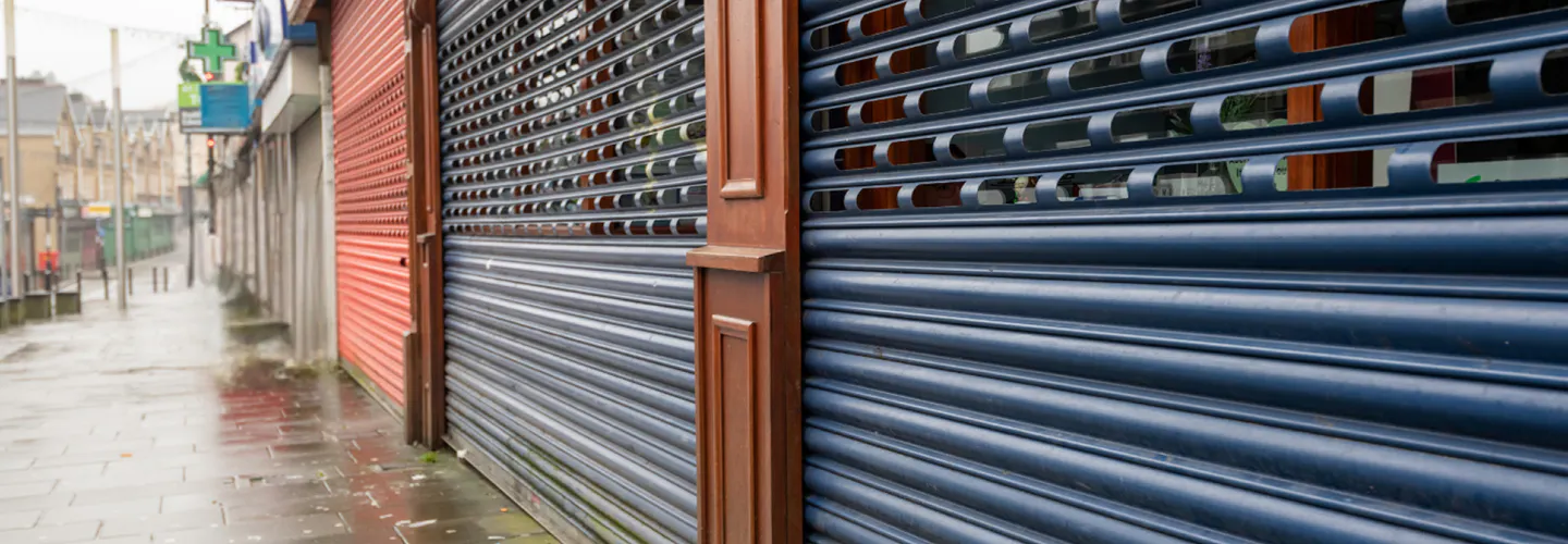 A photo of closed shutters on a rainy street