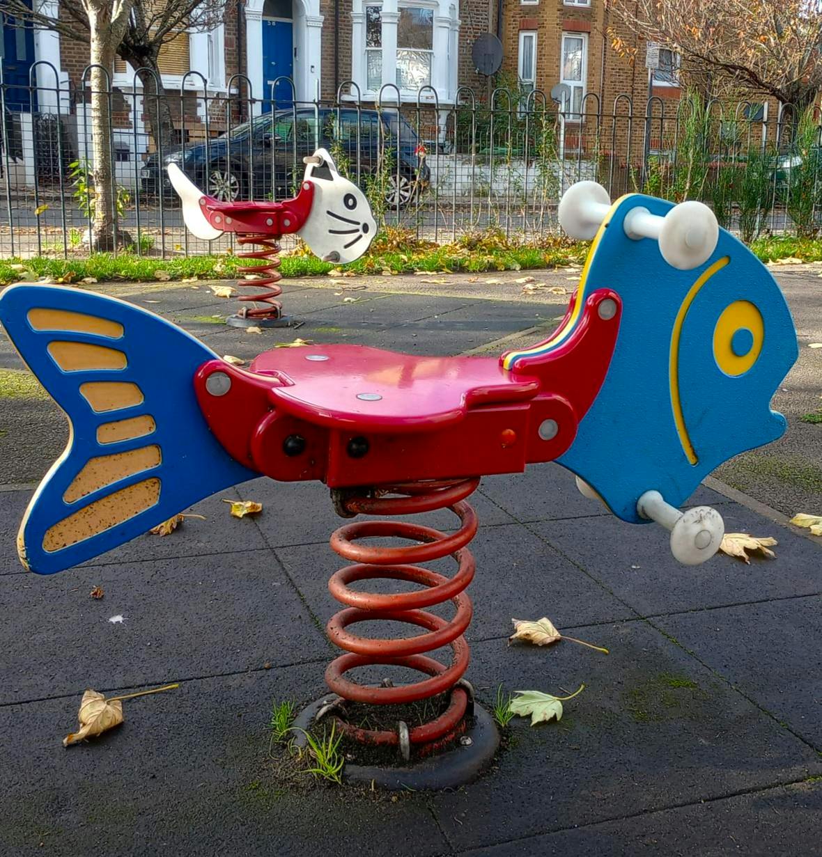 Two pieces of springer play equipment in a park
